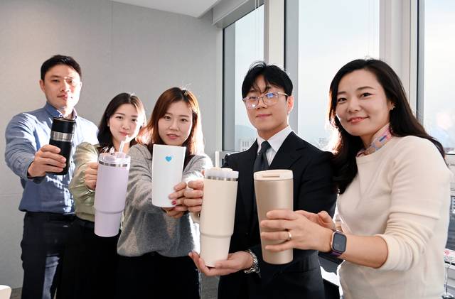 올해로 10년째 종이컵 대신 텀블러 사용을 생활화하고 있는 법무법인 지평 직원들이 최근 서울 중구 세종대로 본사 사무실에서 개인 텀블러를 들어보이고 있다. 윤성호 기자