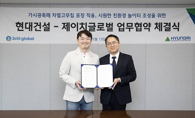 ‘현대건설-제이치글로벌, 가시광촉매 차열고무칩포장 적용’ 업무협약 체결식 사진. (오른쪽부터)현대건설 최광호 건축주택설계실장과 제이치글로벌 오주명 대표가 업무협약 체결식을 마치고 기념사진을 촬영하고 있다. [현대건설]