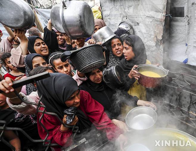 [ 가자시티=신화/뉴시스] 가자지구의 가자시티에 있는 한 급식소에 4월 24일(현지시간) 수 많은 팔레스타인 피난민들이 몰려 들어 무료 급식을 받기 위해 아우성을 치고 있다.  이스라엘 정부가 공식 부인하고 있으나 이스라엘 군은 가자 지구에 기아가 임박했다는 결론을 내리고 있다. 2025.5.14.