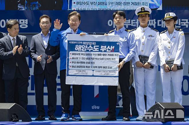 [부산=뉴시스] 권창회 기자 = 이재명 더불어민주당 대선 후보가 14일부산 부산진구 서면 젊음의 거리에서 열린 유세에서 권기흥 에이치라인해운해상직원노조 위원장과 해양수도 부산 협약서에 서명한 뒤 기념촬영을 하고 있다. (공동취재) 2025.05.14. photo@newsis.com