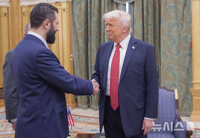 [리야드(사우디아라비아)=AP/뉴시스]도널드 트럼프 미 대통령(오른쪽)이 14일 사우디아라비아 리야드에서 아흐마드 알-사라 시리아 임시 대통령과 악수하고 있다. 2025.05.14.