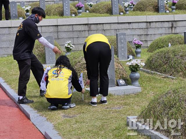 ▲13일 한국도로공사서비스 광주전남권역본부 직원들이 묘역마다 태극기를 꽂는 자원봉사에 참여했다.2025.05.13ⓒ프레시안(김보현)