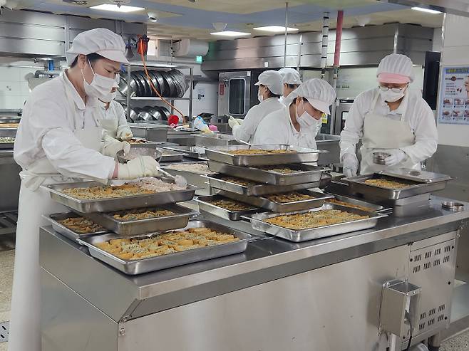 조원고 조리사와 조리원들이 자율선택급식 메뉴로 토핑유부초밥을 만들고 있다. 신연경기자