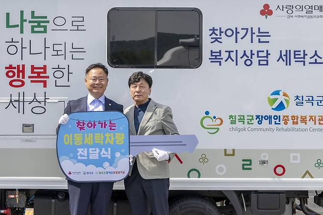 김재욱 칠곡군수(좌측)와 김선래 칠곡군장애인복지관장이 ‘이동세탁 차량’ 전달식을 가지며 기념사진을 촬영하고 있다./칠곡군 제공