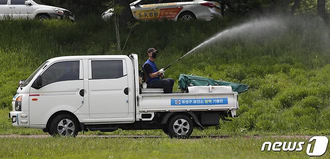 대전 유성구 만년교 인근 하천에서 유성구보건소 방역기동반 직원들이 살인 진드기 방역소독을 하고 있다.  /뉴스1  ⓒ News1 주기철 기자