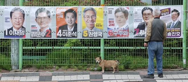 15일 한 유권자가 서울 양천구 목동 한 아파트 단지 내에 부착된 대선 후보 벽보를 살펴보고 있다. 뉴스1
