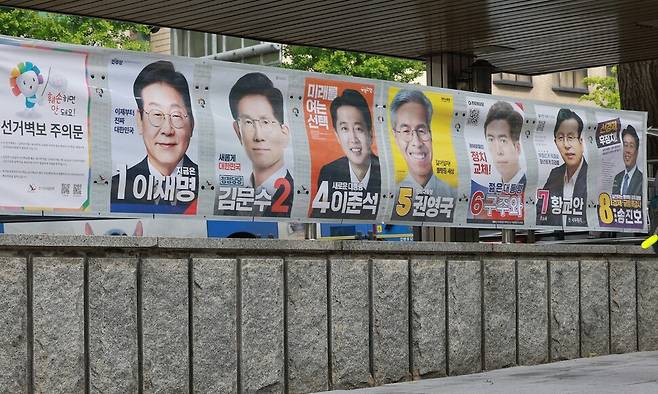 15일 서울 지하철 3호선 무악재역 4번 출구에 첩부된 제21대 대통령 선거 벽보를 어린이가 보며 지나가고 있다. 연합뉴스