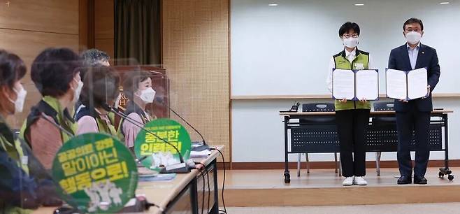 나순자 보건의료노조 위원장(왼쪽)과 권덕철 보건복지부 장관이 2021년 9월 2일 새벽 서울 영등포구 의료기관평가인증원에서 노정 실무교섭이 타결된 뒤 서명한 합의문을 교환하고 기념촬영을 하고 있다. 연합뉴스