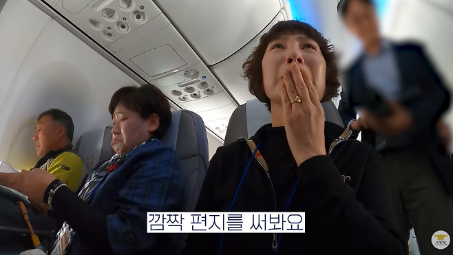 지난 9일 소방청이 마련한 순직 소방관 가족 '마음치유 여행'을 떠나는 항공기 안 모습. 순직 소방관의 목소리로 된 음성편지를 듣는 가족들. (소방청 제공)