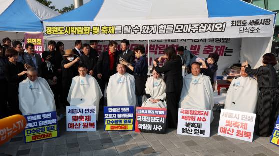 국민의힘 소속 세종시의원들이 지난 10월 8일 세종시청 앞에서 삭발식을 하고 있다. 이들은 최민호 세종시장의 핵심 공약인 정원도시박람회와 빛 축제 개최를 위한 예산안 통과를 촉구하며 삭발식을 진행했다. 연합뉴스