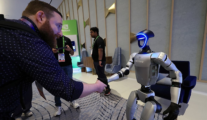 CES 2025 개막인 지난 1월7일 오전(현지시간) 젠슨 황 엔비디아 최고경영자(CEO) 글로벌 기자간담회가 열린 미국 네바다주 라스베이거스 퐁텐블루 호텔 엔비디아 전시관에서 휴머노이드 로봇 유니트리 G1이 관람객과 악수하고 있다. 연합뉴스