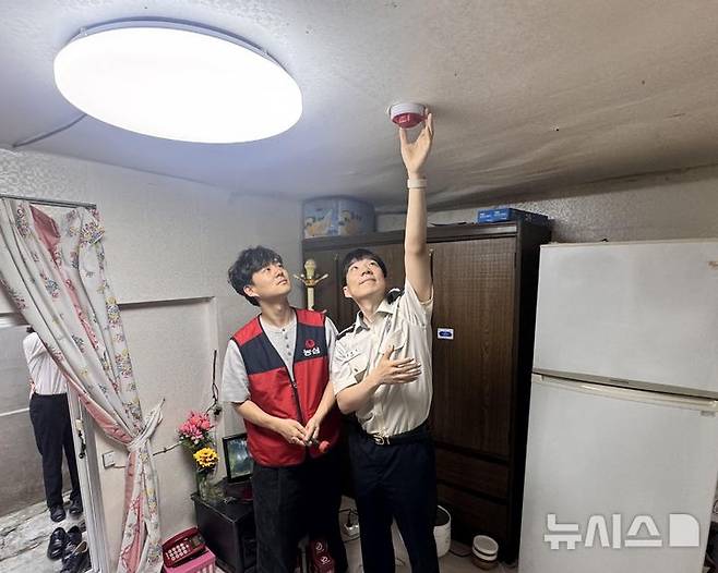 [인천=뉴시스] 지난 14일 인천소방본부와 농심 관계자가 인천 동구 만석동 괭이부리마을의 한 주거지 내부에서 단독경보형 감지기를 설치하고 있다. (사진=인천소방본부 제공) 2025.05.15. photo@newsis.com