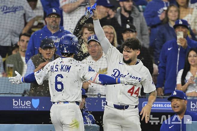 [로스앤젤레스=AP/뉴시스] LA 다저스의 김혜성(왼쪽)이 14일(현지 시간) 미 캘리포니아주 로스앤젤레스의 다저스타디움에서 열린 2025 메이저리그 애슬레틱스와의 경기 5회 말 동점을 기록하는 1점 홈런(시즌 1호)을 친 후 더그아웃에서 해바라기씨 세례를 받고 있다. 2025.05.15.