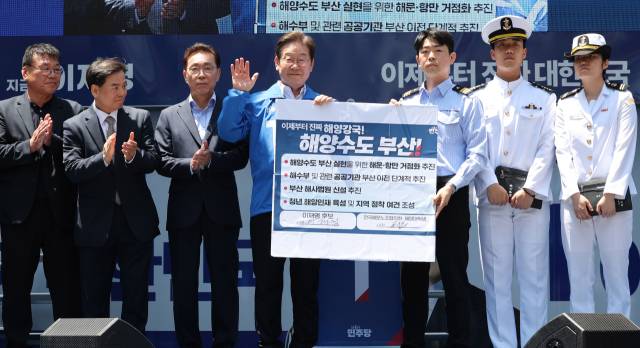 이재명 더불어민주당 대선 후보가 14일 부산 부산진구 서면거리에서 '해양수도부산 이전 공약서'에 서명한 뒤 기념촬영을 하고 있다. 부산=오승현 기자