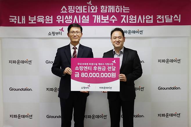 지난 15일 서울 마포구 지파운데이션 본사에서 진행된 기부금 전달식에 참석한 한상욱 쇼핑엔티 대표이사(왼쪽)와 박충관 지파운데이션 대표가 기념촬영을 하고 있다(쇼핑엔티 제공).