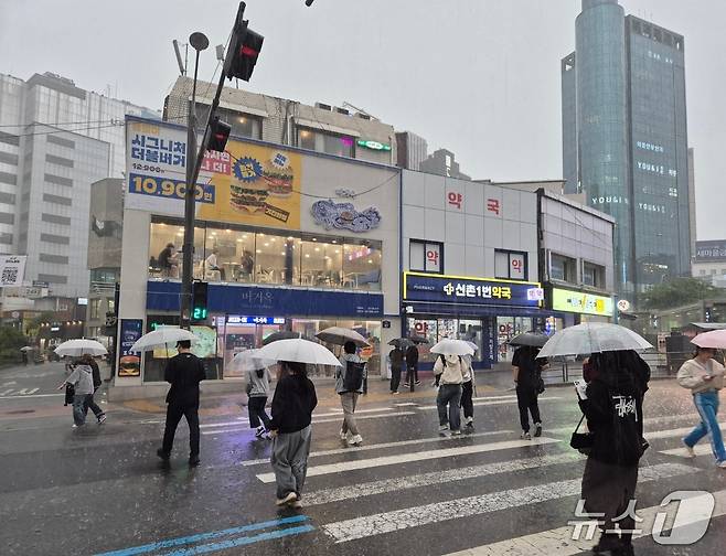 서울 전역에 호우주의보가 내린 16일 오후 지하철 2호선 신촌역 인근 횡단보도에서 우산을 쓴 시민들이 발걸음을 재촉하고 있다. / 뉴스1 신윤하 기자