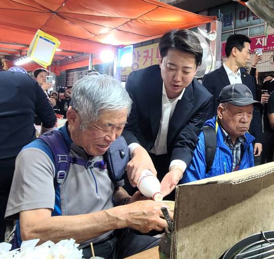 16일 오후 이준석 개혁신당 대선 후보가 천안중앙시장 노점에서 어르신에게 술을 따르고 있다. 윤평호 기자