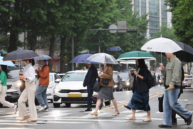 지난 15일 서울 광화문 부근에서 시민들이 우산을 쓰고 이동하고 있다. 연합뉴스
