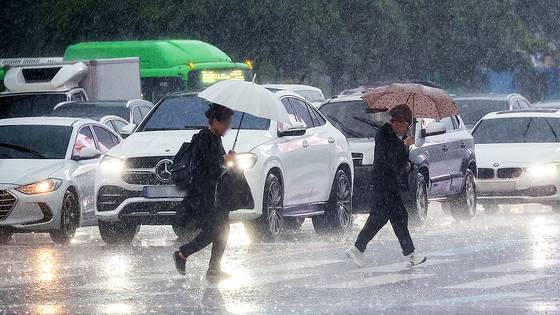 비가 내린 16일 서울 광화문사거리에서 시민들이 우산을 쓴 채 이동하고 있다. 연합뉴스