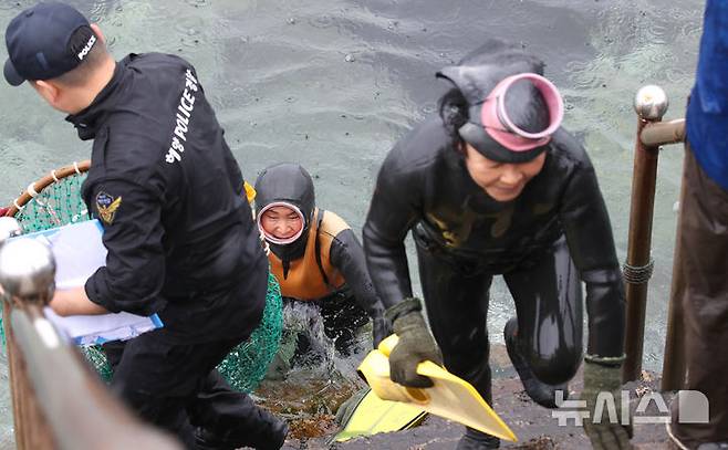 [제주=뉴시스] 우장호 기자 = 16일 오후 제주시 탑동방파제 해상에서 제주해양경찰서와 제주소방서, 해녀구조대가 포함된 해양재난구조대가 참가해 민관 합동 해상 수색 구조훈련을 하고 있다. 사진은 해녀구조대가 익수자 발생을 가정한 인명 구조 훈련을 마치고 뭍으로 올라오는 모습. 2025.05.16. woo1223@newsis.com