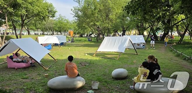 주말인 17일 경북 성주 성밖숲 일원에서 열리고 있는 '성주 참외·생명 문화축제'에 참여한 가족들이 힐링포레스트 존에 설치된 힐링 스팟에서 휴식을 취하고 있다. 축제는 오는 18일까지 열린다. 2025.5.17/뉴스1 ⓒ News1 정우용 기자