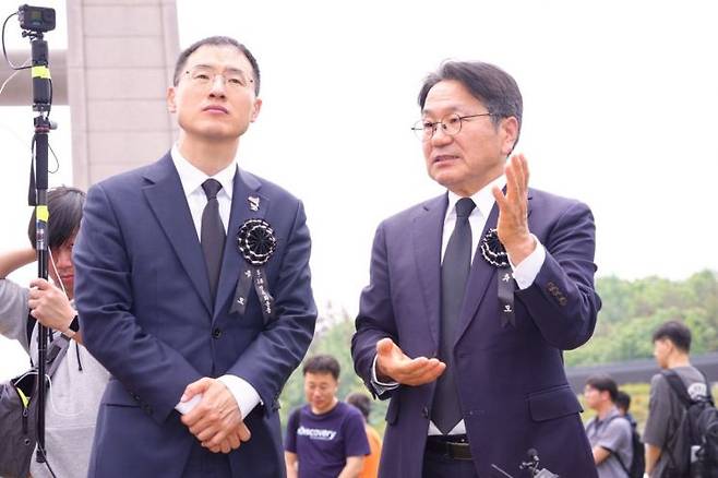 강기정 광주시장이 17일 김상욱 의원과 국립5·18민주묘지에 안장된 양창근·문재학·안종필 열사 등의 묘지를 둘러보고, '그 소년들'이 꿈꿨던 민주 세상에 대해 설명하고 있다. 광주시 제공