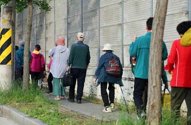 금호타이어 광주공장 화재가 발생한 17일 오후 광주 광산구 소촌동 한 아파트 인근 도로에서 주민들이 대피소로 가는 버스를 기다리고 있다. 연합뉴스
