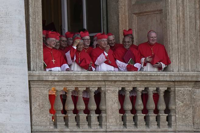 지난 8일(현지시각) 바티칸 성 베드로 대성당의 발코니 중 한 곳에서 새 교황 레오 14세를 선출한 추기경들이 환한 표정으로 광장을 내려다보고 있다. AP 연합뉴스