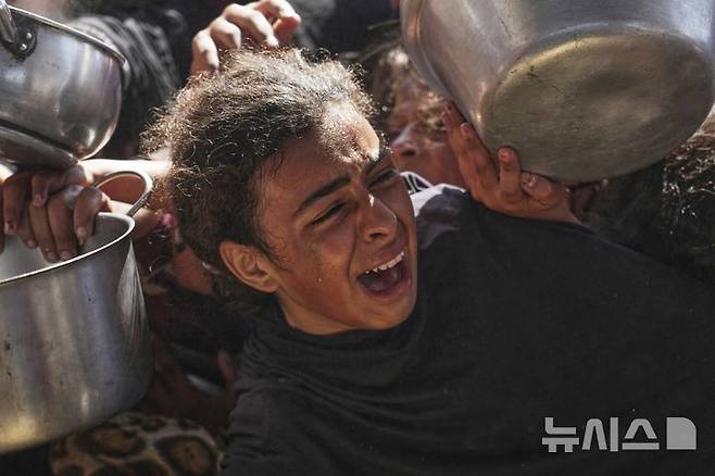 [칸유니스=AP/뉴시스] 9일(현지 시간) 가자지구 남부 칸유니스에서 음식 배급을 받으려는 한 팔레스타인 소녀가 울부짖고 있다. 2025.05.10.