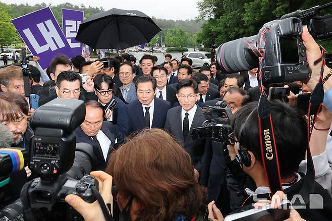 [광주=뉴시스] 조성봉 기자= 김문수 국민의힘 대통령 후보가 17일 오전 김 후보의 광주 방문을 반대하는 대학생들의 피켓 시위를 뒤로 하고 5.18민주묘지로 이동하고 있다.(공동취재) 2025.05.17. photo@newsis.com