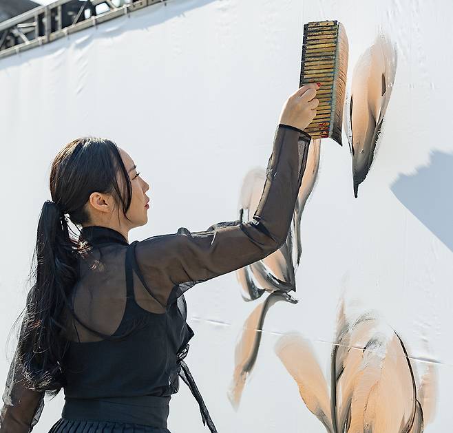 강원도 강릉시 홍제동 글씨당에서 김소영 작가가 검은 한복을 입고 배접붓과 여러 종류의 대붓을 이용해 캘리그래피 퍼포먼스를 선보이고 있다.