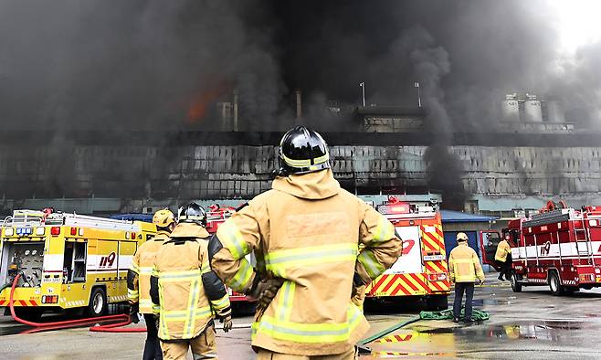 17일 광주 광산구 소촌동 금호타이어 광주공장 화재 현장에서 진화 작업에 투입된 소방대원이 치솟는 검은 연기를 바라보고 있다. 뉴시스