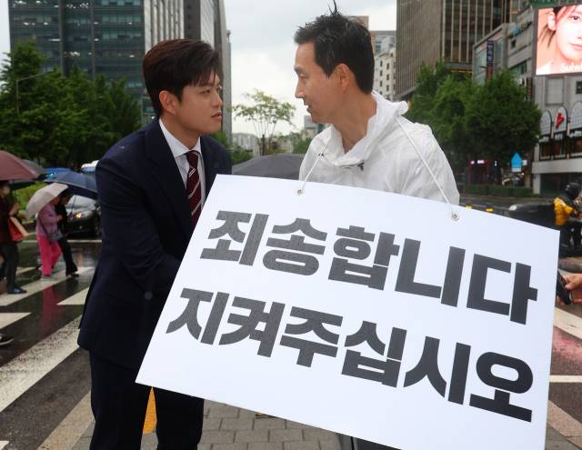 김용태 국민의힘 비상대책위원장(왼쪽)이 16일 서울 종로구 세종대로사거리를 찾아 지지호소 피켓팅을 하고 있는 김기흥 전 대통령실 부대변인을 격려하고 있다. 연합뉴스
