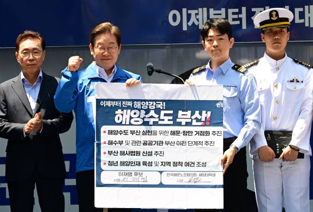 이재명 더불어민주당 대선 후보가 14일 부산 부산진구 서면거리에서 '해양수도부산 이전 공약서'에 서명한 뒤 기념촬영을 하고 있다. 부산=오승현 기자