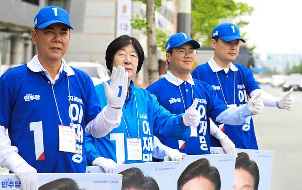 ▲ 18일 대전 유성구 연구단지네거리에서 민주당 선거운동원들이 시민들을 향해 손을 흔들고 있다.