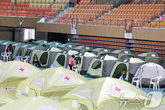 전날 발생한 금호타이어 광주공장 화재가 이튿날인 18일에도 이어지는 가운데 광주 남구 광주여대 체육관에 마련된 피해 주민을 위한 대피소에서 주민들이 쉬고 있다. 2025.5.18/뉴스1 ⓒ News1 박지현 기자