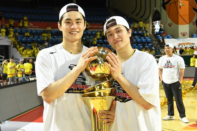 “우리가 새 왕조 탄생의 미래” 프로농구 창원 LG 유기상(왼쪽)과 양준석이 17일 2024~2025 프로농구 챔피언결정전 우승을 차지한 뒤 우승 트로피를 어루만지며 기념 촬영을 하고 있다. KBL 제공