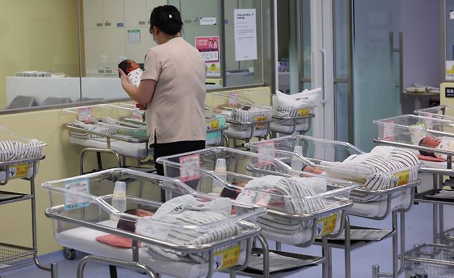 A nurse takes care of a newborn at a hospital in Incheon on Feb. 26. [YONHAP]