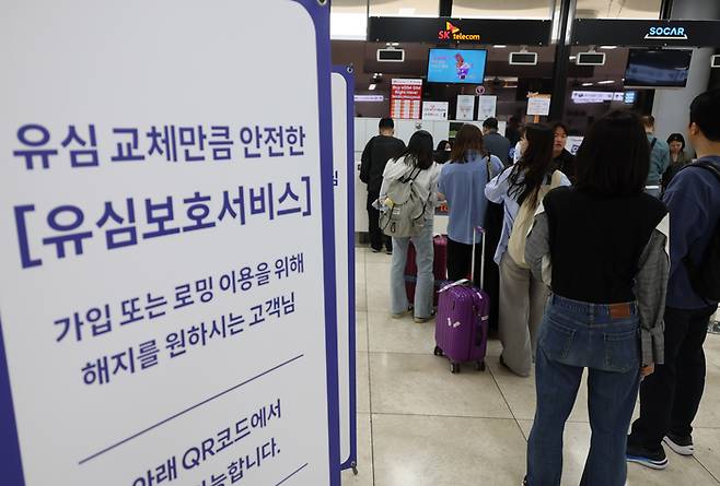 서울 강서구 김포공항 국제선 청사 내 SK텔레콤 부스에서 여행객들이 유심 교체를 위해 대기하고 있다. [사진 = 연합뉴스]