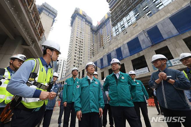 [서울=뉴시스] 박상우 국토교통부 장관이 지난해 7월12일 오전 장마철 대응 및 폭염 대비 상황 점검을 위해 서울 강동구 천호동 공동주택 재건축 정비사업 현장을 찾아 허유득 포스코이앤씨 안전팀장의 설명을 듣는 모습. 2025.05.18. (사진=뉴시스DB) photo@newsis.com