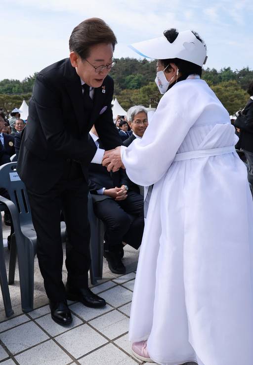 더불어민주당 이재명 대선 후보가 18일 광주 북구 국립5·18민주묘지에서 열린 제45주년 5·18민주화운동 기념식에서 오월어머니회 회원과 악수하고 있다. 대통령실통신사진기자단