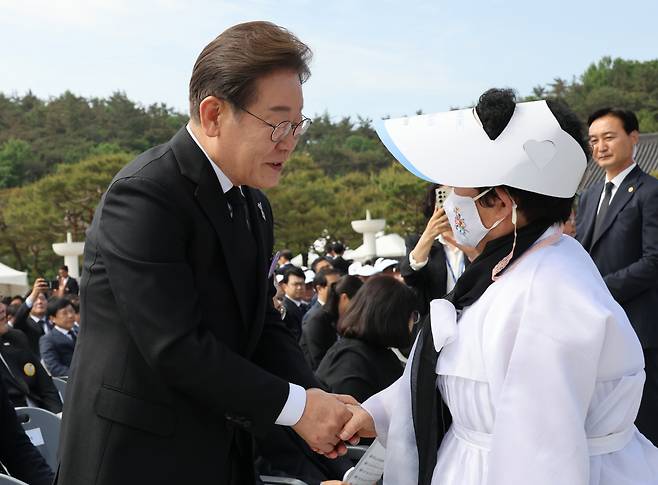 더불어민주당 이재명 대선후보(왼쪽)가 18일 광주 북구 국립 5∙18 민주 묘지에서 열린 ‘5∙18민주화운동 기념식’에서 오월 어머니회 회원과 인사하고 있다. 대통령실사진기자단