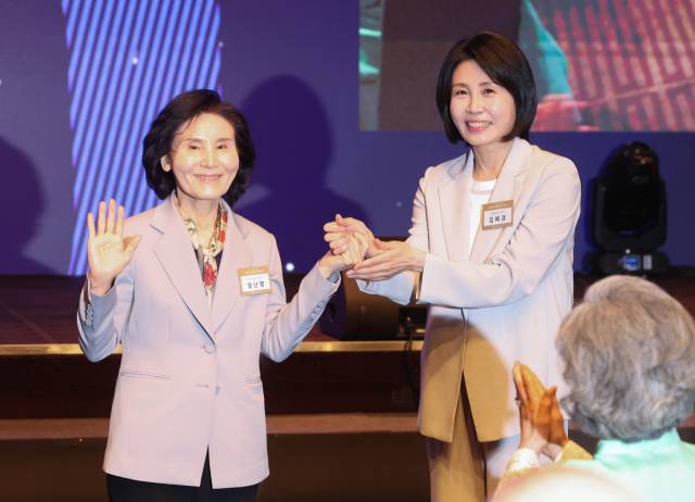 김문수 국민의힘 대선 후보의 부인 설난영(왼쪽) 씨와 이재명 더불어민주당 대선 후보의 부인 김혜경 씨가 12일 서울 중구 신라호텔에서 열린 ‘조계종 중앙신도회 창립 70주년 기념식’에서 손을 맞잡고 있다. 연합뉴스