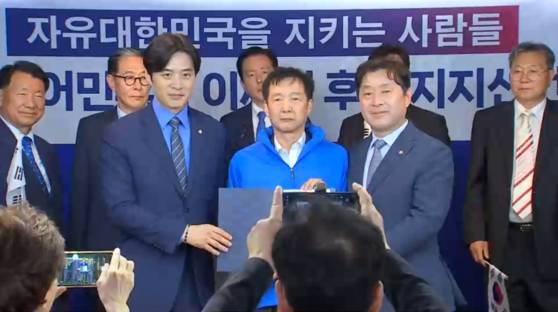 김동렬 박근혜 서포터즈 회장(가운데)이 오늘(19일) 서울 여의도 더불어민주당 당사에서 당 선대위 전국민화합위원회 상임위원장에 임명된 뒤 파란색 점퍼를 입은 모습. 〈사진=JTBC〉