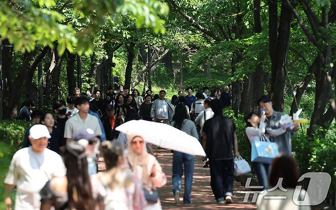 화창한 날씨를 보인 지난 18일 서울 송파구 석촌호수에서 나들이에 나선 시민들이 여유로운 주말을 보내고 있다. 2025.5.18/뉴스1 ⓒ News1 장수영 기자