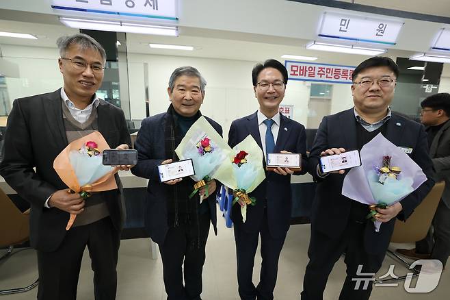 고창군이 도내 최초로 집적회로(IC·integrated Circuit) 칩 내장 주민등록증(이하 ‘IC칩 주민등록증’) 발급수수료를 면제한다. 심덕섭 고창군수(오른쪽 두번째)와 성홍제 주민자치위원장(세번째)이 모바일주민등록증을 발급받고 기념사진을 찍고 있다.(고창구 제공, 재판매 및 DB금지)