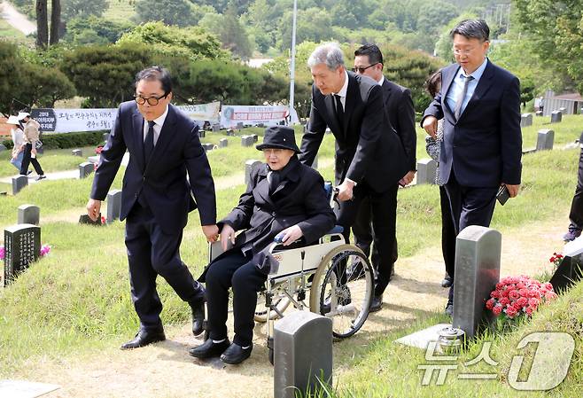 노태우 전 대통령의 아내 김옥숙씨가 19일 광주 북구 망월동 민족민주열사묘역(구묘역)에 참배하고 있다. 이날 김 여사의 참배에는 아들인 노재헌 재단법인 동아시아문화센터 이사장이 함께했다. 2025.5.19/뉴스1 ⓒ News1 이수민 기자