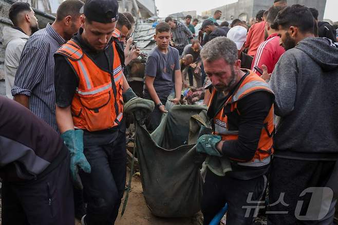 팔레스타인 구조대가 18일(현지시간) 가자지구 북부 자발리아의 알 사프타위 지역에서 이스라엘 공습으로 숨진 이의 시신을 수습하고 있다. 2025.05.18. ⓒ AFP=뉴스1 ⓒ News1 이지예 객원기자