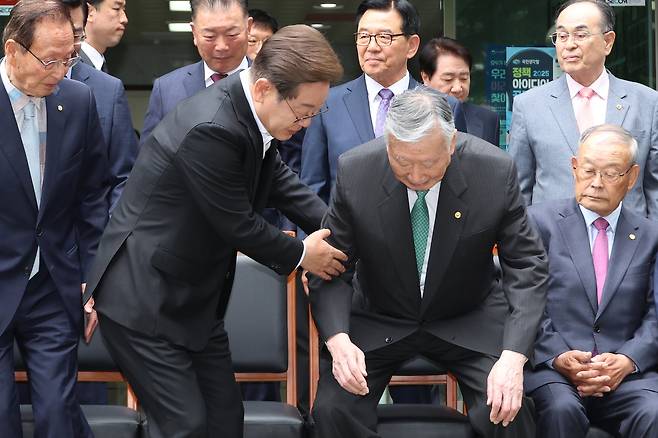 이재명 더불어민주당 대통령 후보가 19일 서울 용산구 대한노인회관을 방문, 기념촬영 자리에 앉는 이중근 회장을 부축하고 있다. /뉴스1