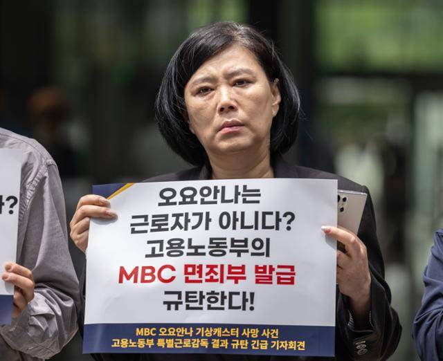 19일 서울 중구 서울고용노동청 앞에서 열린 MBC 기상캐스터였던 고(故) 오요안나씨 특별감독결과 규탄 기자회견에서 오씨의 어머니 장연미씨가 손팻말을 들고 있다. 이날 회견에서 장씨는 오씨가 근로기준법상 근로자로 인정되지 않는다는 고용노동부의 특별근로감독 결과에 대해 "절대로 받아들일 수 없다"고 밝혔다. 연합뉴스